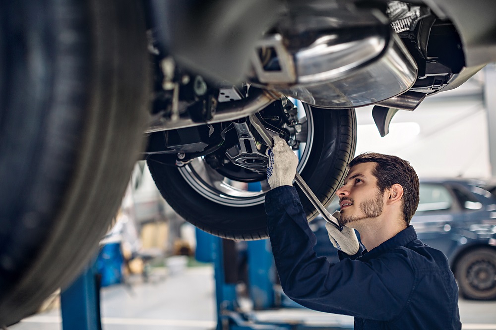 Mechanic working on underside of vehicle